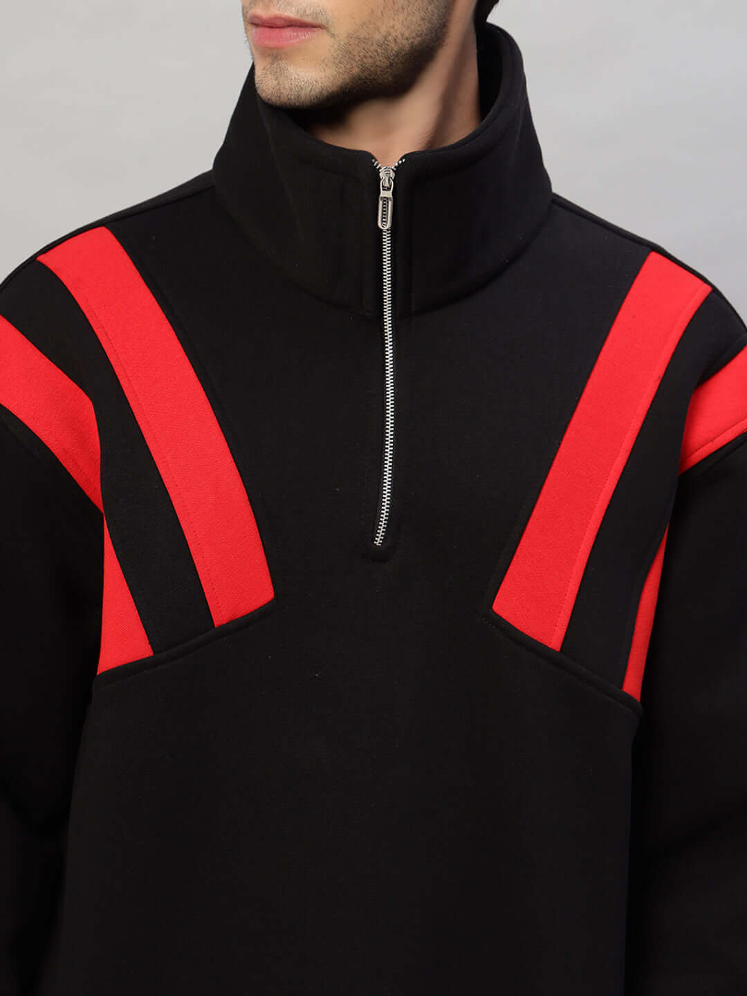 Black and red colorblock fleece jacket with zip-up collar, featuring modern design and contemporary style.