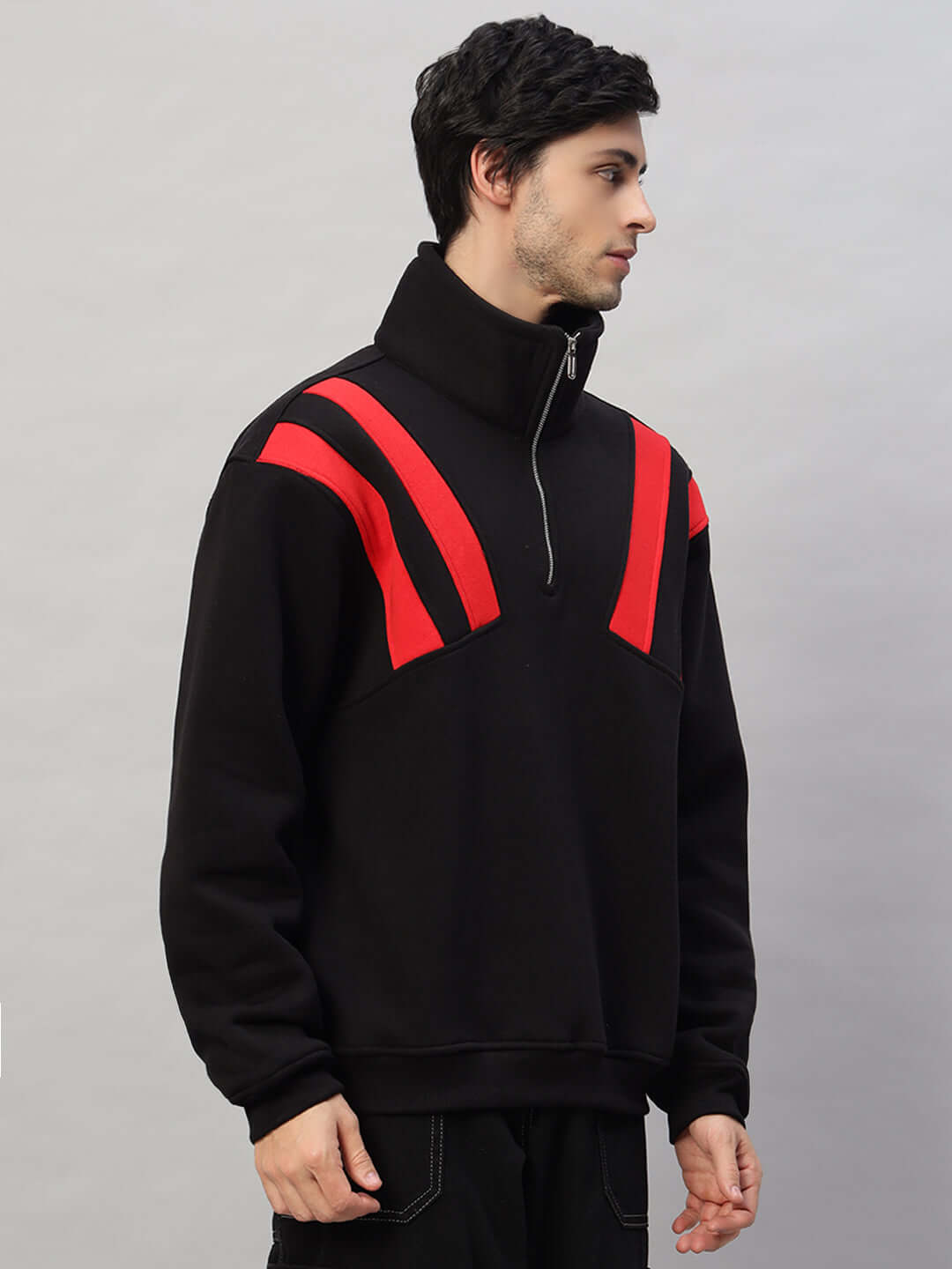Black and red colorblock fleece jacket with high collar and zipper, modeled by a man, showcasing modern and sporty style.