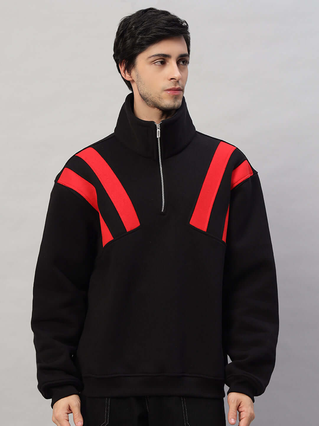 Black and red colorblock fleece jacket with crossbar design, worn by a model. Stylish, warm outerwear ideal for casual wear.