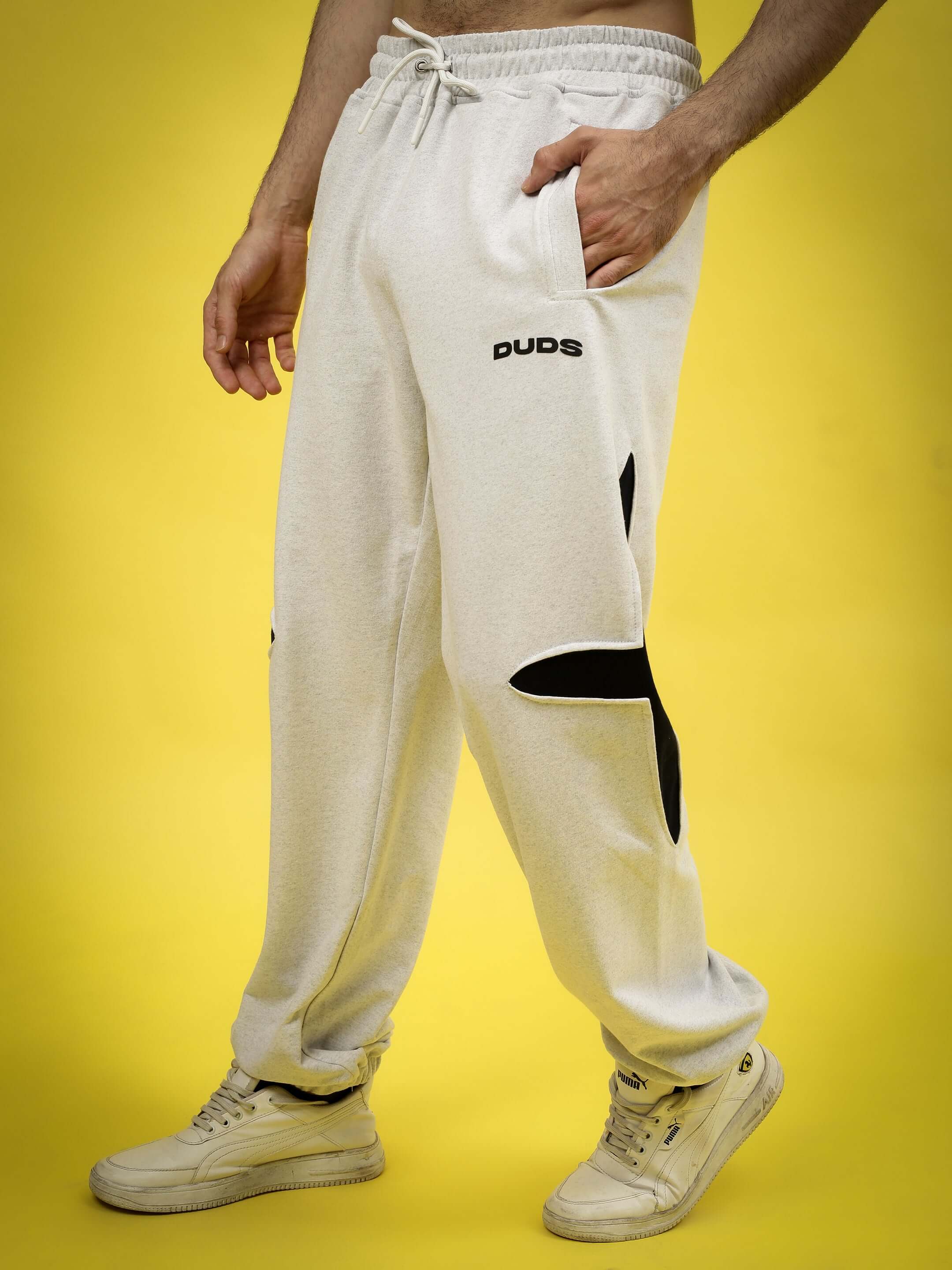 Light grey Crossed Star Jogger by DUDS, featuring a comfortable fit and customizable size options, displayed on a yellow background.