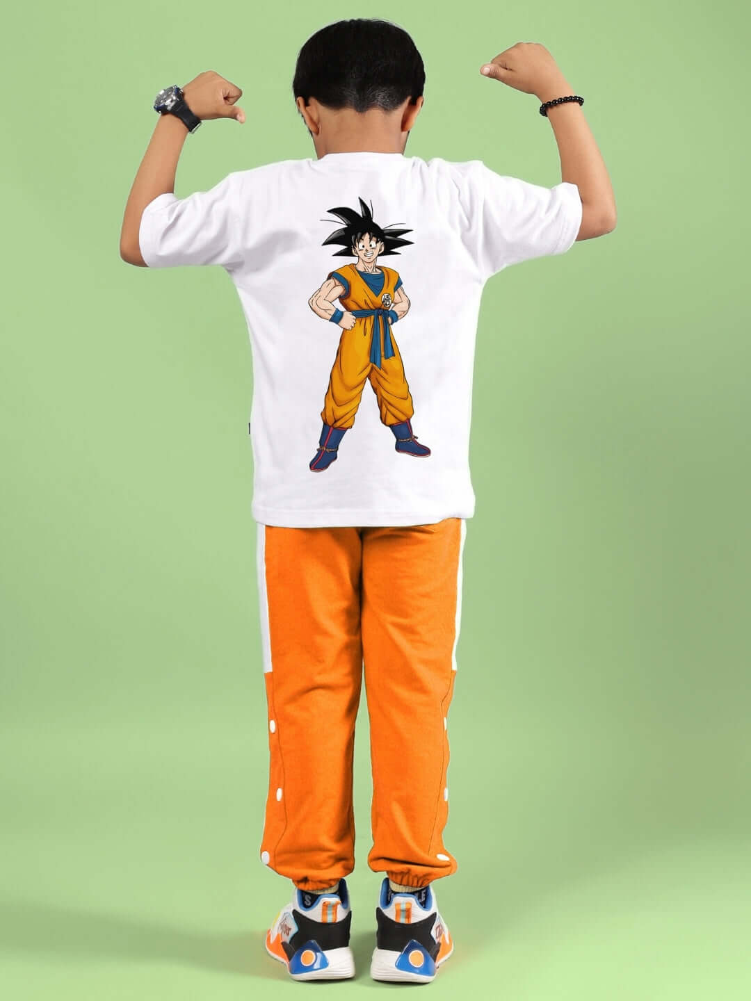 Child wearing white-orange crossover co-ord set with graphic t-shirt and orange pants, showcasing vibrant and playful style.