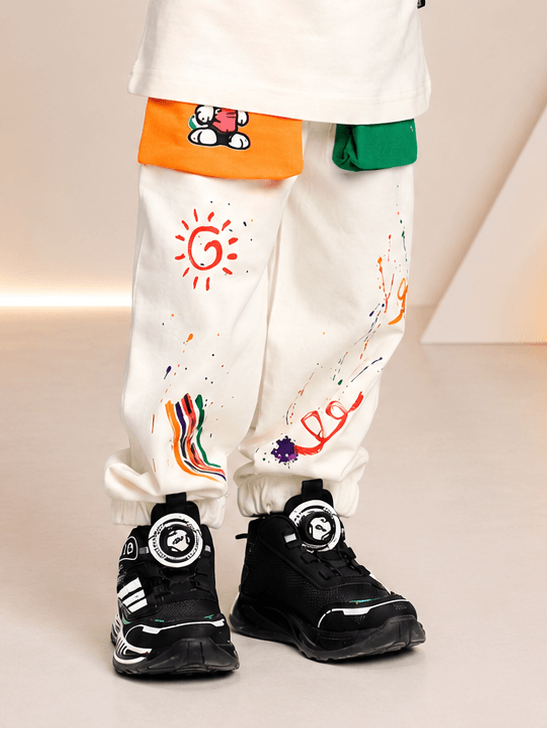 CUTE PUPPY JOGGER FOR BOYS AND GIRLS OFF WHITE MULTI with colorful pockets and art splashes, paired with black sneakers.