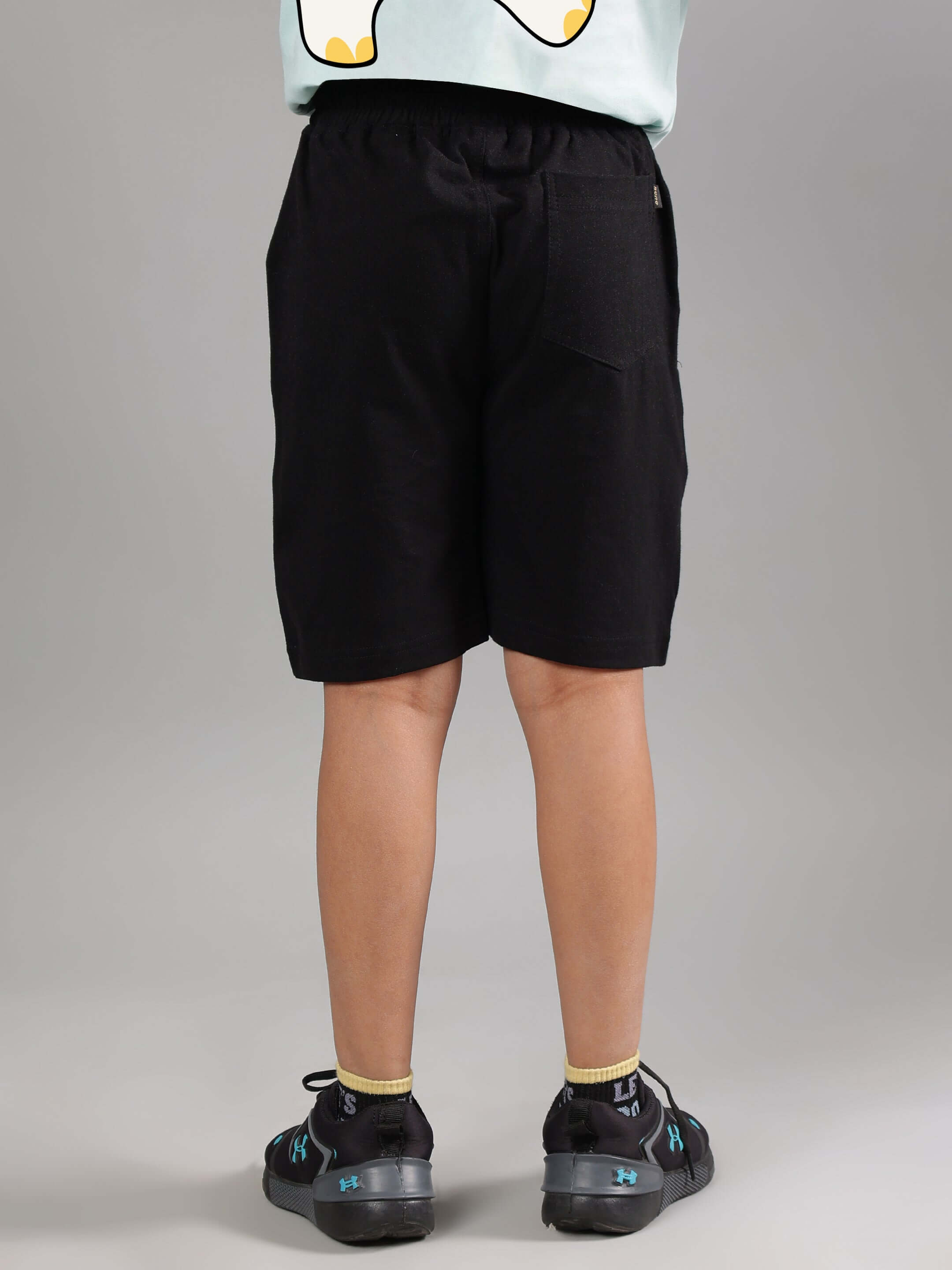 Rear view of child wearing black cute elephant shorts, tailored for boys and girls, by DUDS. Available for custom fit and made to order.