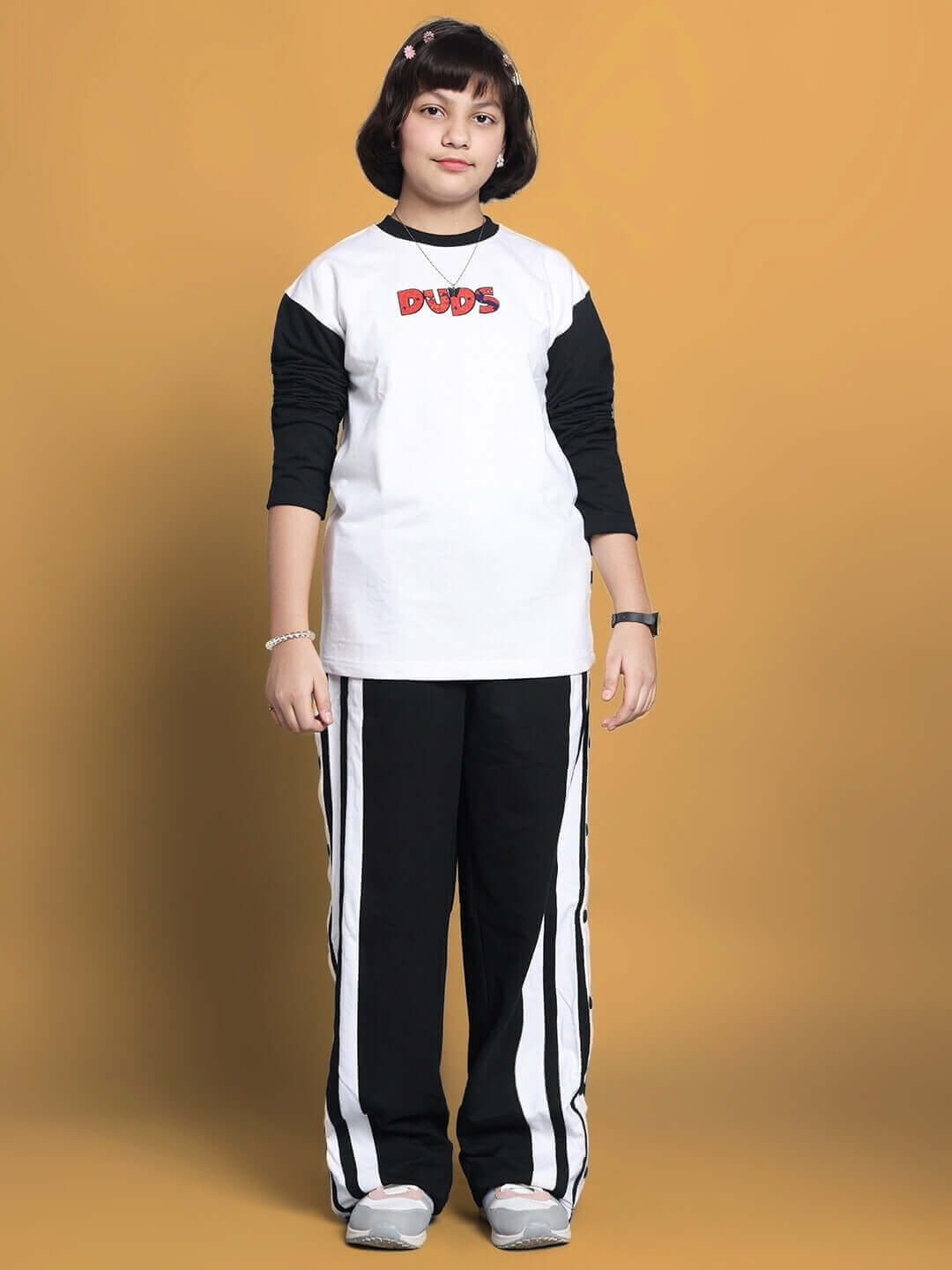 Child wearing BITSY white-black co-ord set by DUDS with 'DUDS' logo, made-to-order apparel for boys and girls, customizable sizes available.