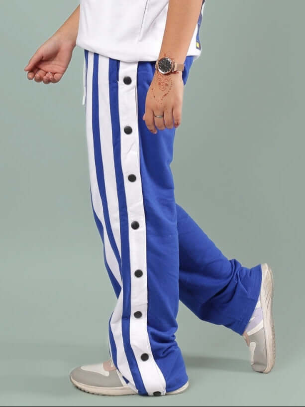 Person wearing DANCER JOGGER FOR BOYS & GIRLS ROYAL BLUE, side view with stripe design and buttons.
