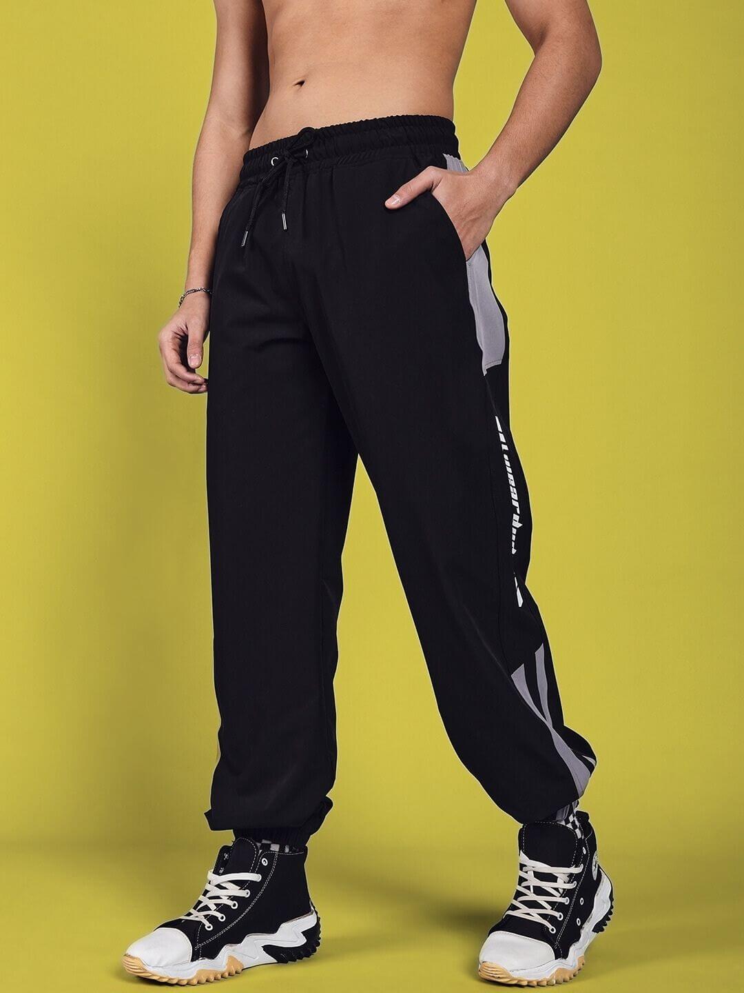 Model wearing Danny Relaxed Fit Cargo Pants in black, showcasing customizable fit and handmade quality against a yellow background.