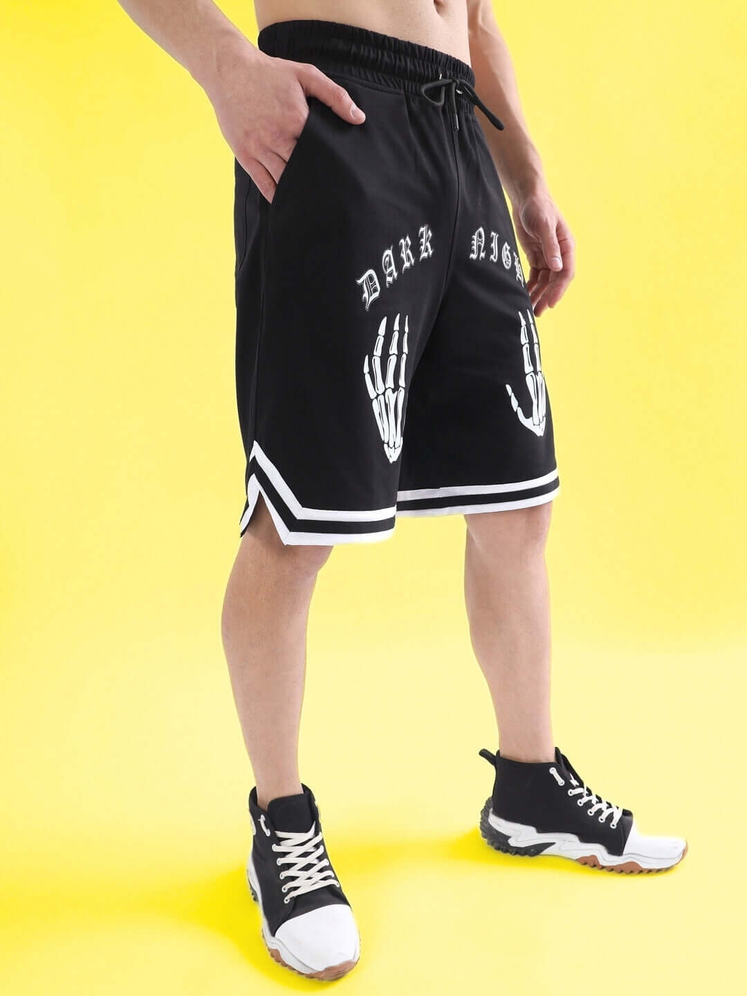 Model wearing DARK NIGHT regular fit black shorts with skeleton hand design, available for custom fit; fashion-forward streetwear.