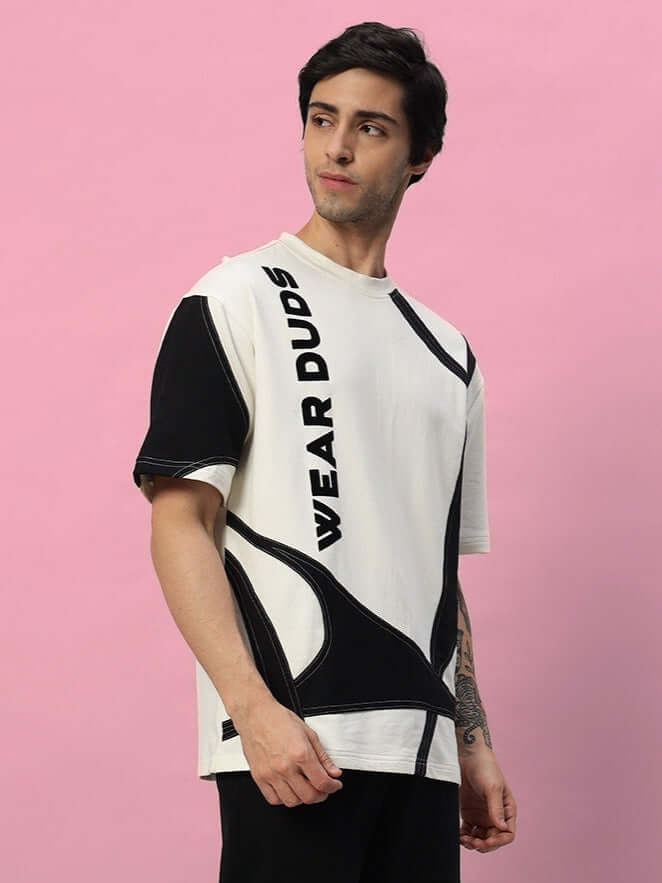 Model wearing DAVID DESIGNER OVERSIZED T-SHIRT OFF WHITE BLACK with modern style on pink background.