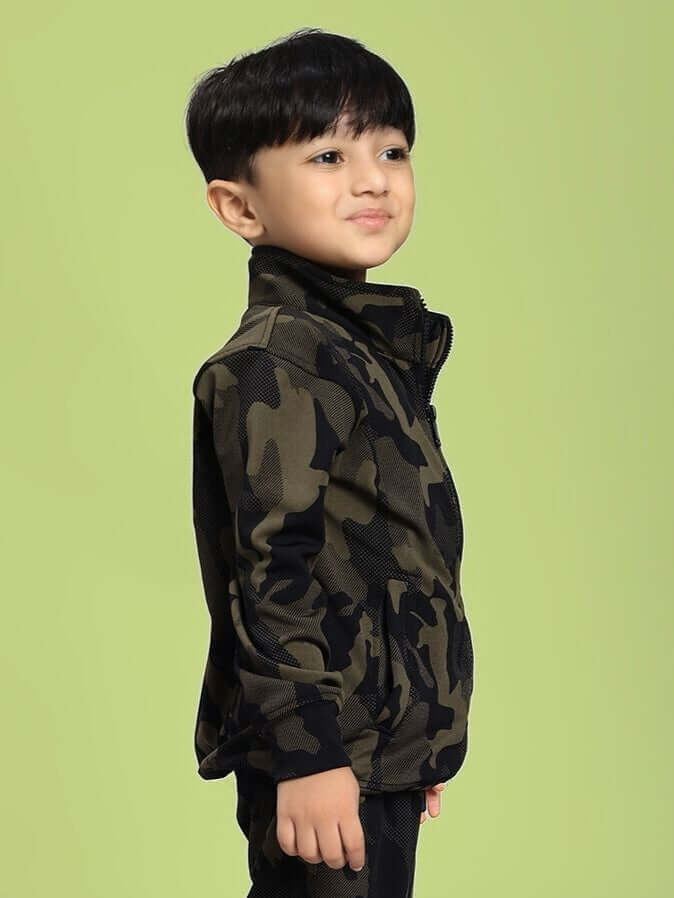 Boy wearing DEFENCE CAMOFLAUGE JACKET FOR BOYS AND GIRLS CAMO GREEN, side view, camo pattern, fleece fabric, green background.