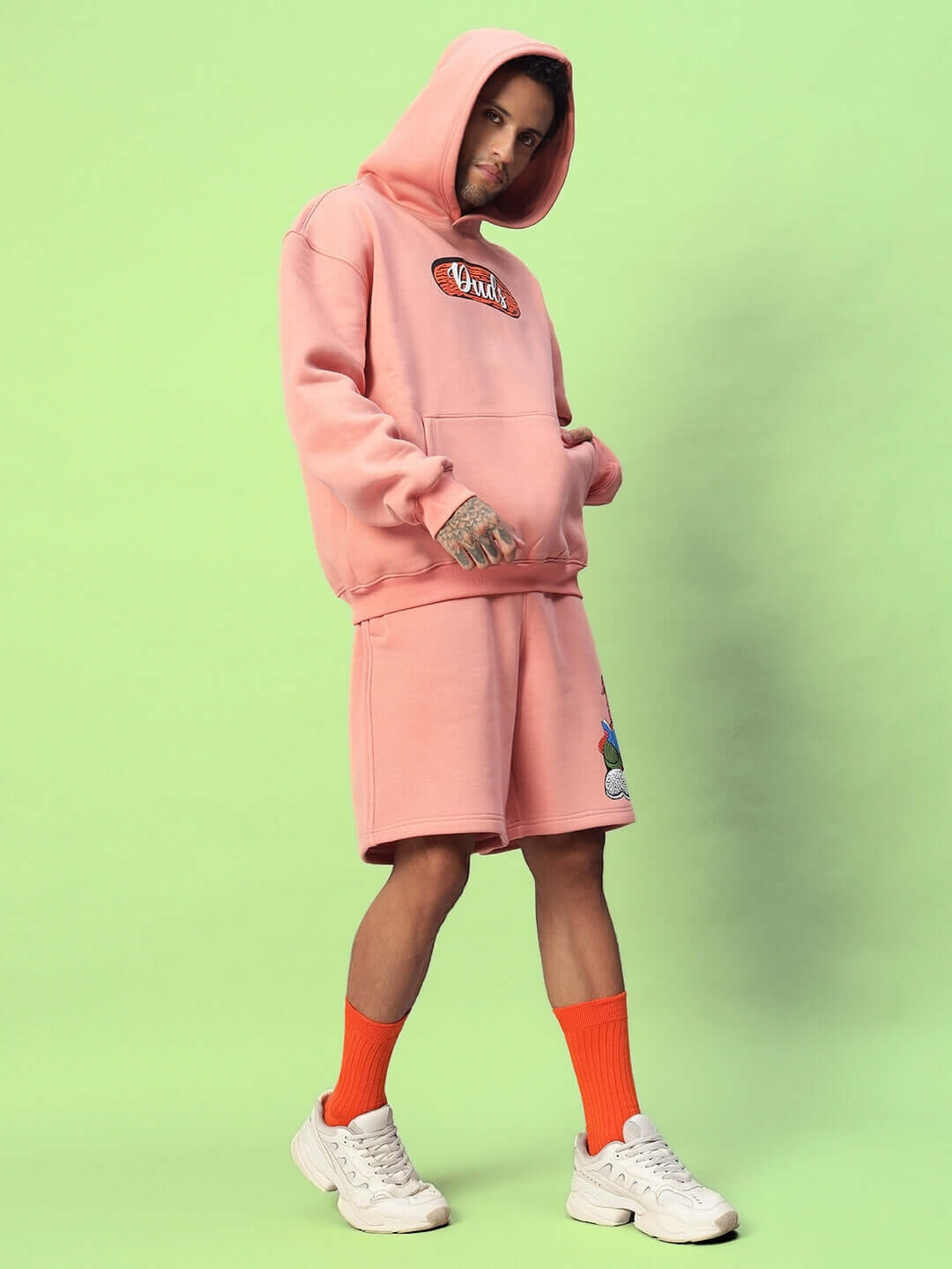 Model wearing DELIBERATE FLEECE CO-ORD PEACH loungewear set, featuring a peach hoodie and shorts, perfect for cozy elegance.