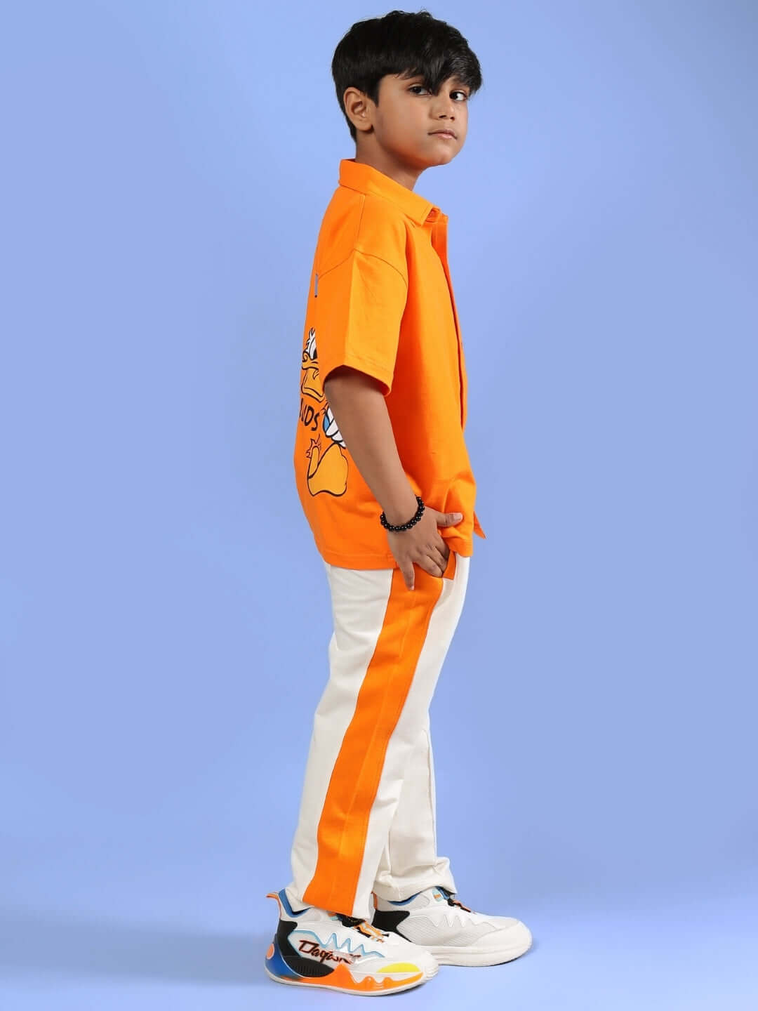 Child wearing DELLA CO-ORD FOR BOYS & GIRLS ORANGE set, featuring vibrant orange color and sporty design, perfect for active kids.