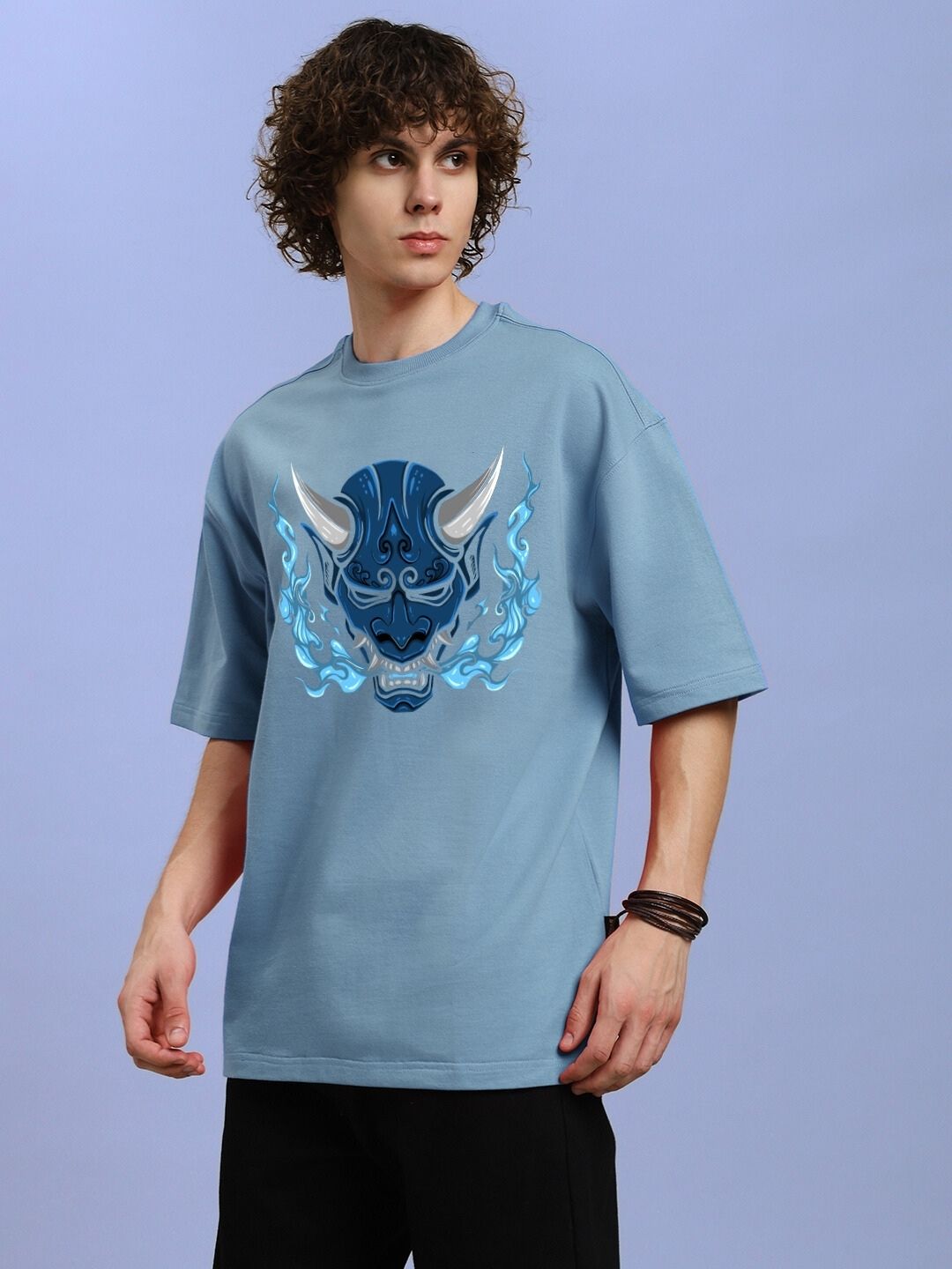 Model wearing DEMON PRINTED OVER-SIZED T-SHIRT LIGHT BLUE with bold demon graphic and relaxed fit.