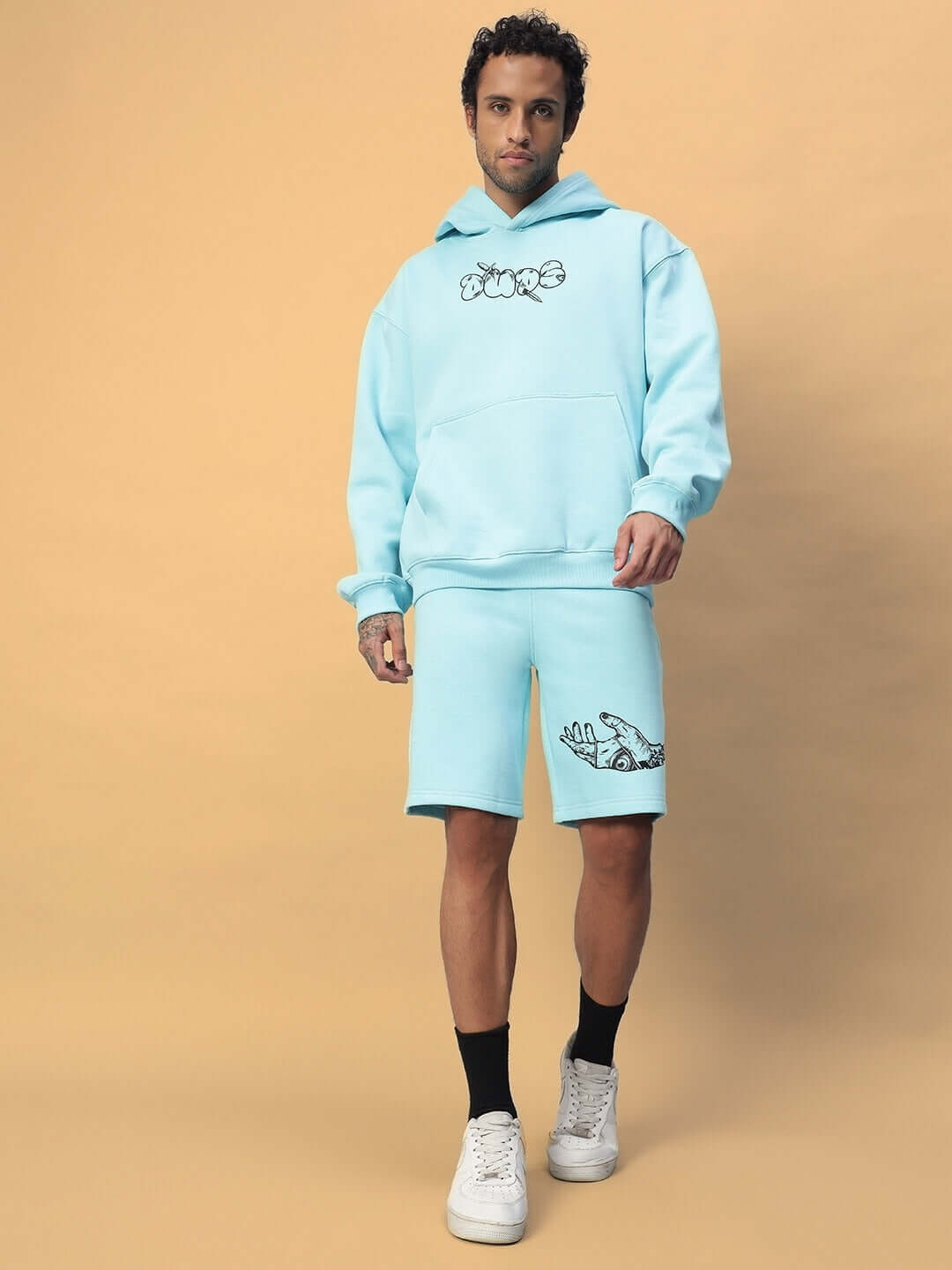 Man wearing WEARDUDS DEMON FLEECE CO-ORD SKY BLUE, showcasing the stylish and comfortable blue fleece outfit against a beige background.