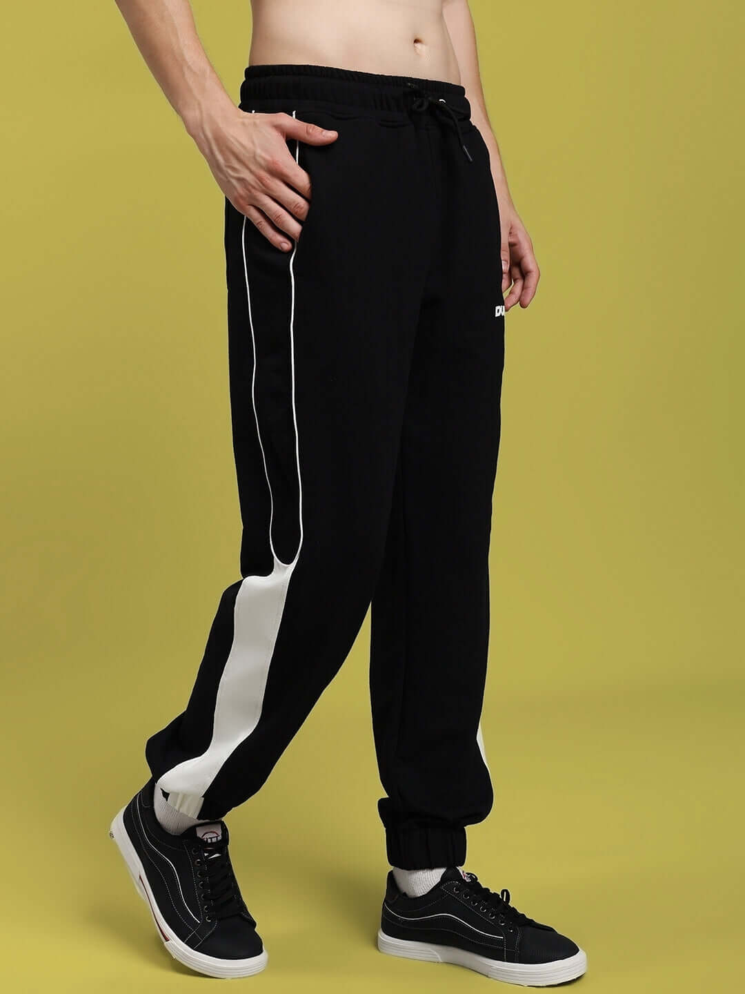 Model wearing Denver Relaxed Fit Joggers in black with white side stripe, showcasing comfortable style and custom fit options by DUDS.