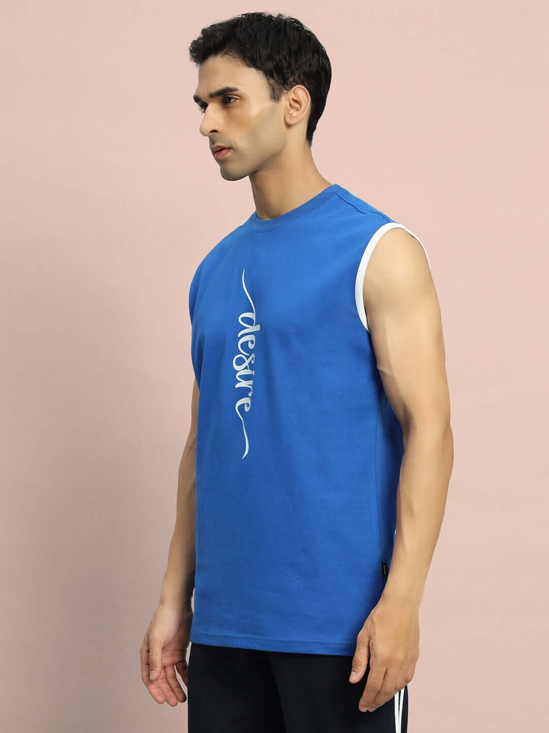 Model wearing DESIRE GYM T-SHIRT in royal blue, showcasing sleeveless athletic design, well-suited for custom fit options.
