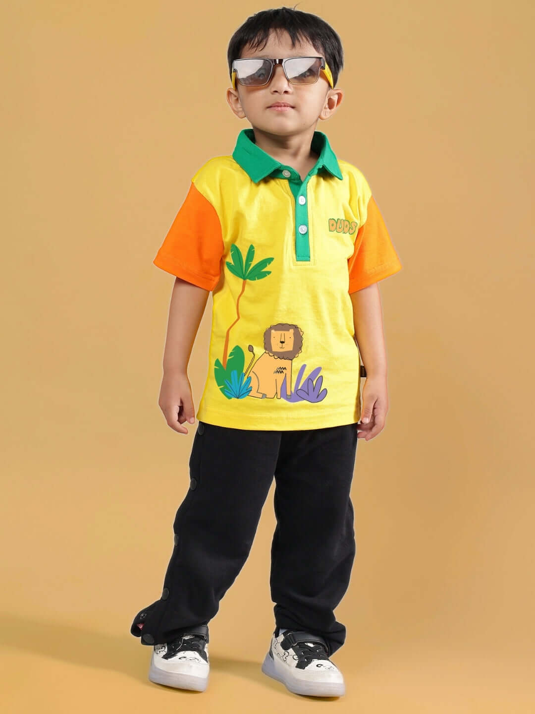 Child wearing yellow-black DIBRU co-ord set with a lion print, sunglasses, and casual shoes, ideal for boys and girls.