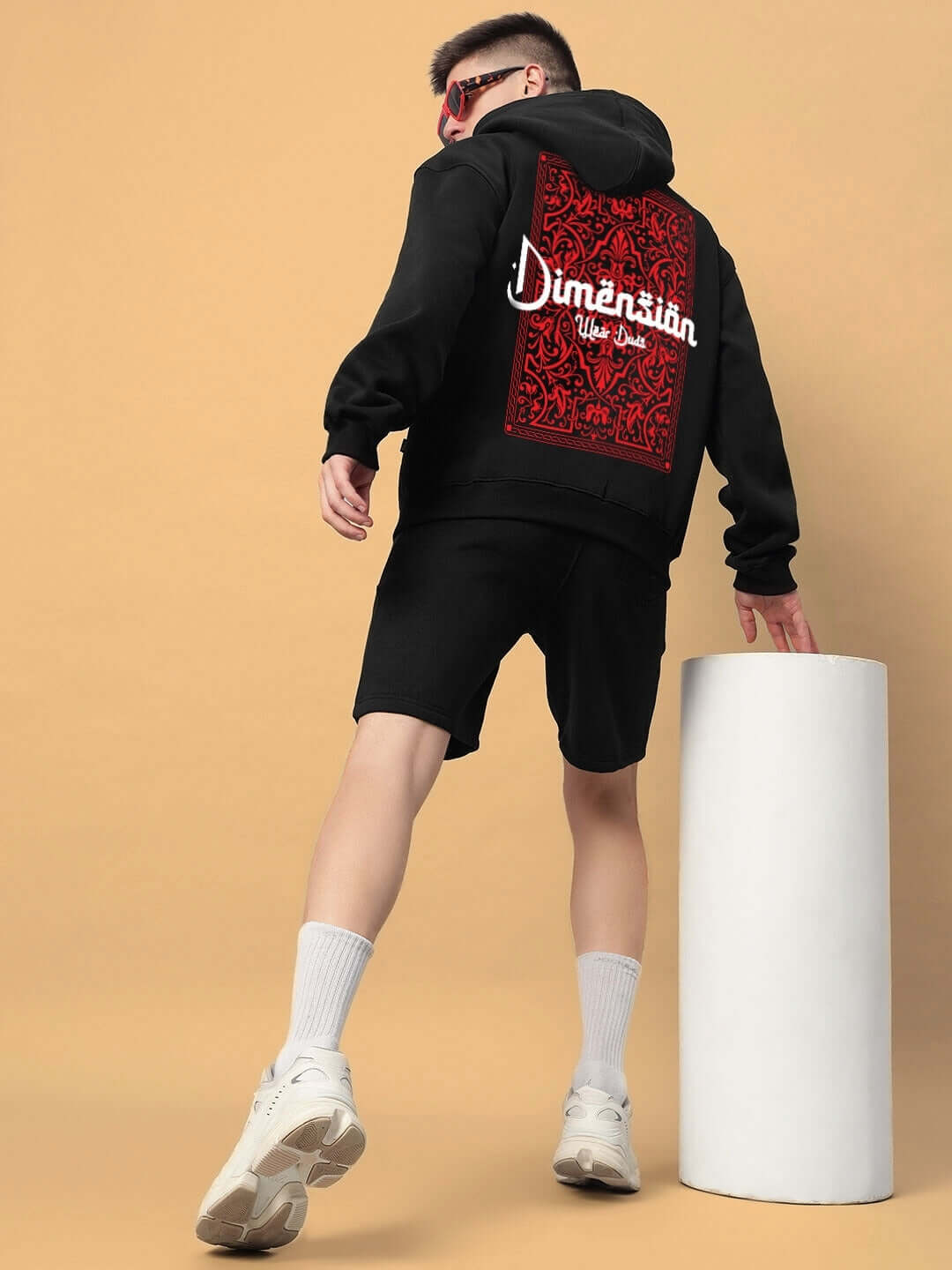 DIMENSION COTTON FLEECE CO-ORD BLACK unisex set with hoodie and shorts, featuring red back design, worn by model against neutral background.