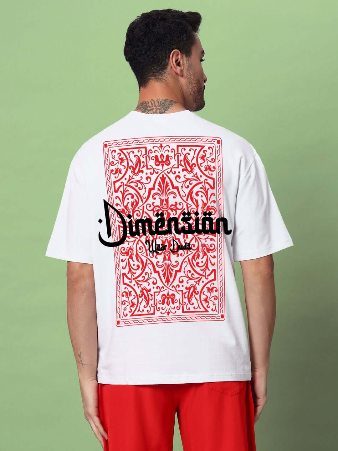 Man wearing Dimension oversized white t-shirt with red patterned back design, made of premium cotton blend. Perfect for casual wear.