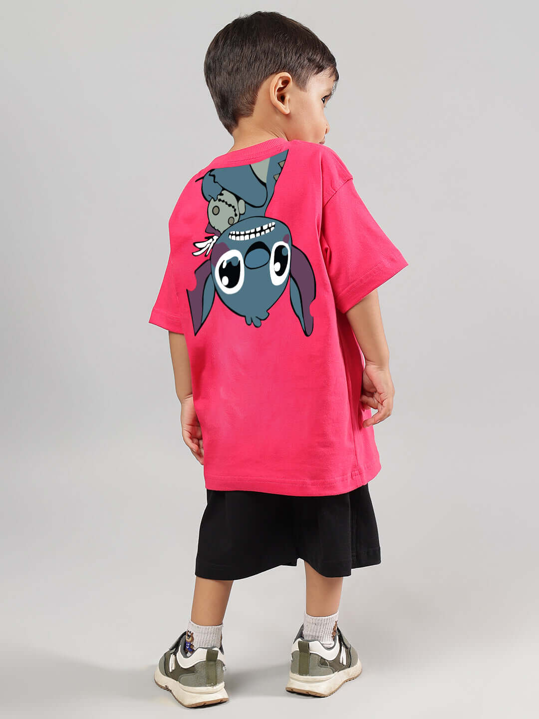 Child wearing DISNEY LILO CO-ORD FOR BOYS GIRLS PINK-BLACK with Stitch graphic, showcasing pink shirt and black shorts.
