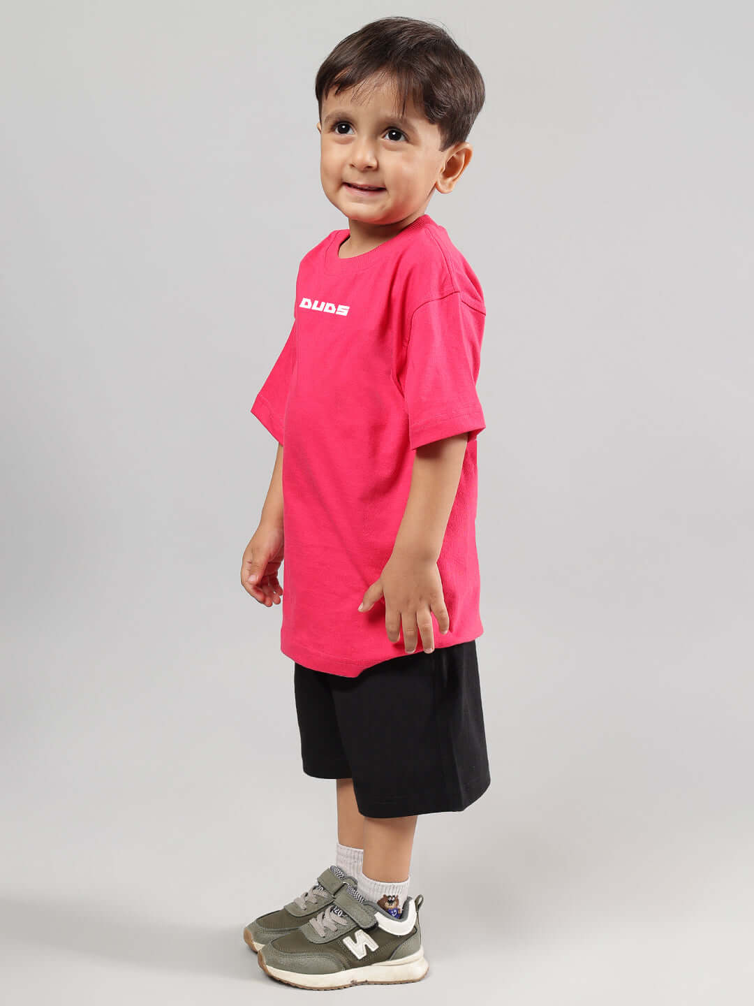 Young child wearing Disney Lilo Co-Ord for Boys Girls Pink-Black outfit, featuring a pink shirt and black shorts, standing sideways.