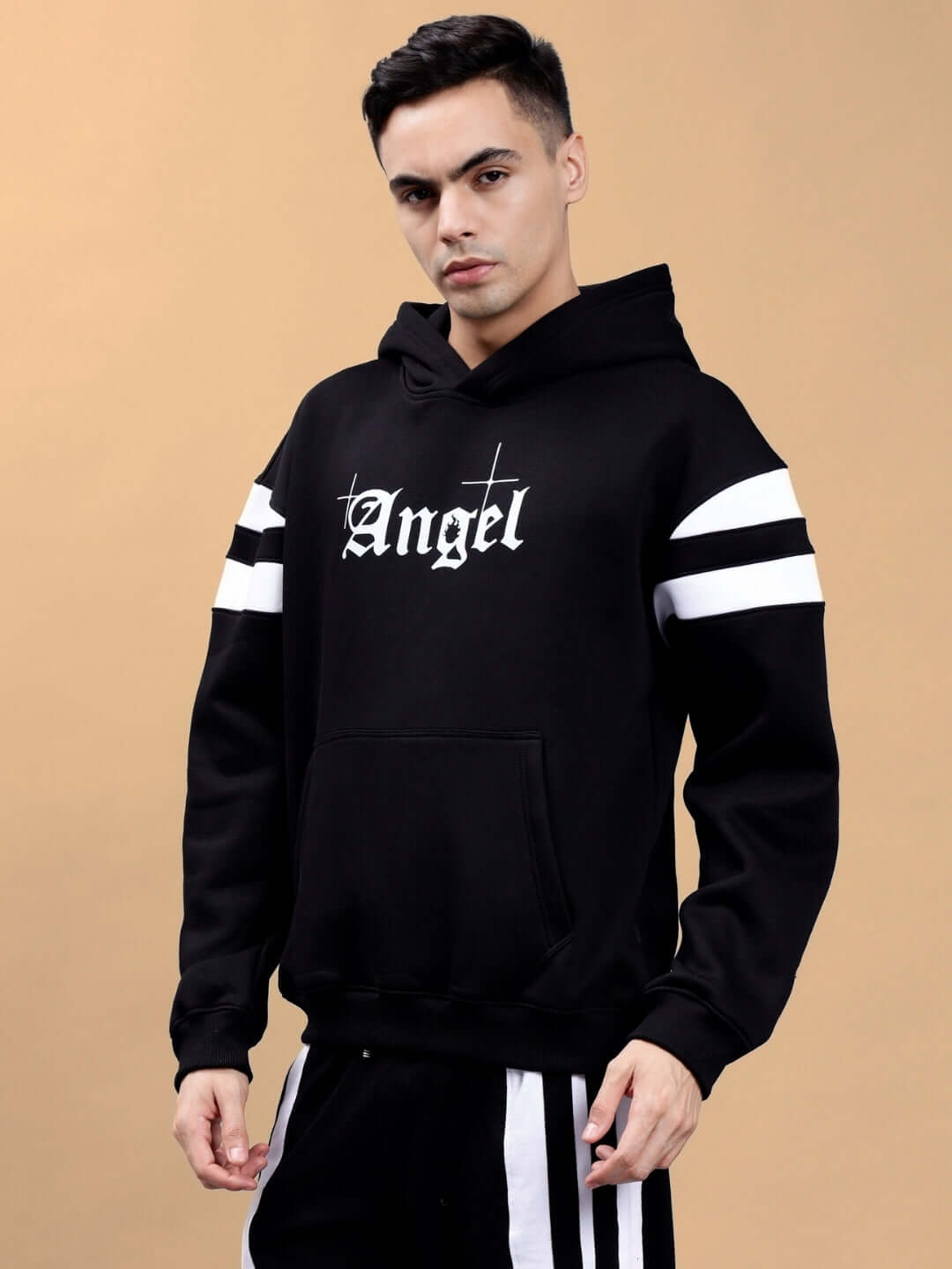 Model wearing a black Divine Spirit colorblock oversized hoodie with 'Angel' text and white stripe accents.