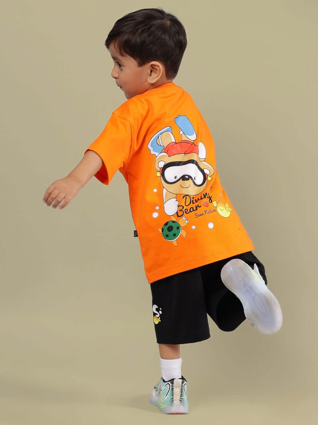 Young child wearing DIVING BEAR CO-ORD FOR BOYS & GIRLS ORANGE-BLACK outfit with playful diving graphic on the back.