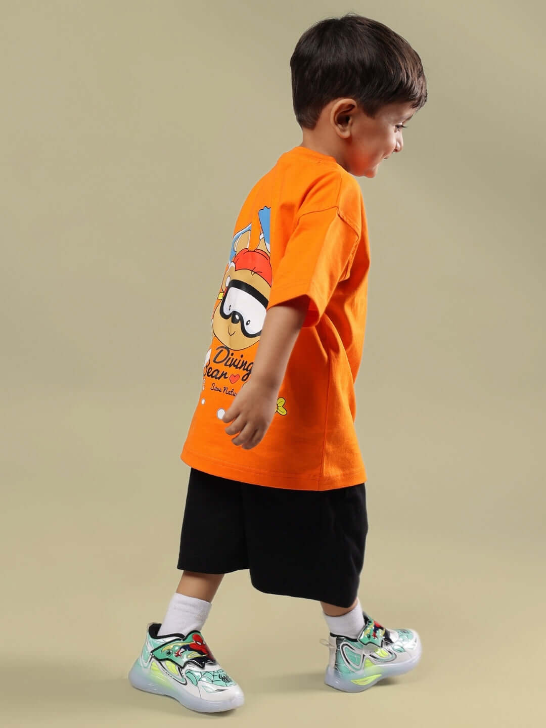 Young boy wearing DIVING BEAR T-SHIRT FOR BOYS GIRLS ORANGE with playful bear print, showcasing fun and adventurous style.