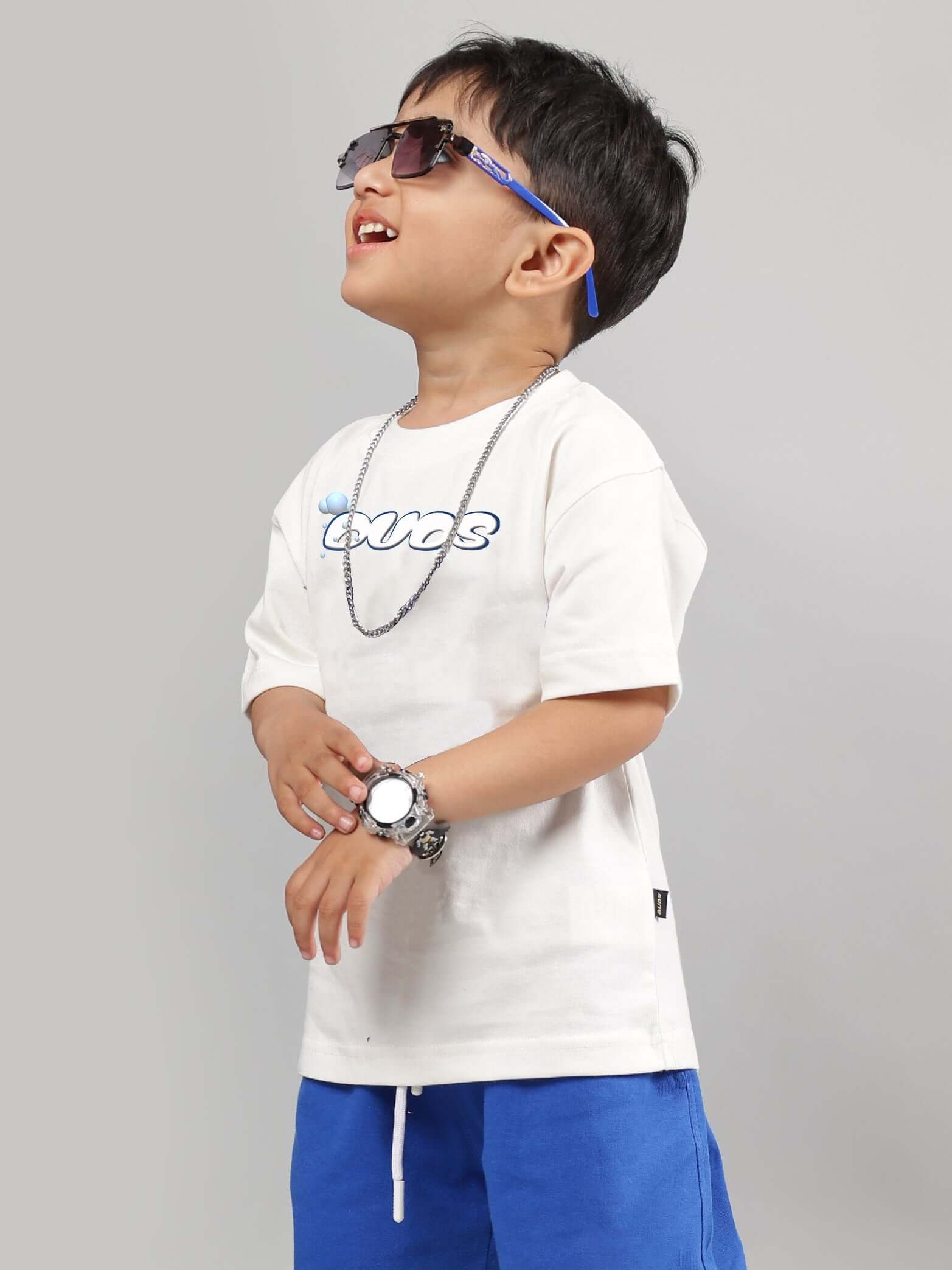 Child wearing off-white Doraemon t-shirt for boys and girls, stylish with sunglasses and a necklace.