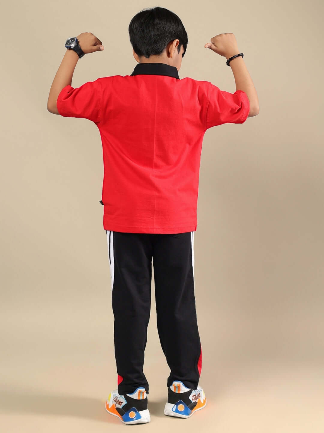 Back view of a child wearing the DORIC CO-ORD FOR BOYS & GIRLS RED-BLACK outfit, showcasing sporty style and vibrant colors.