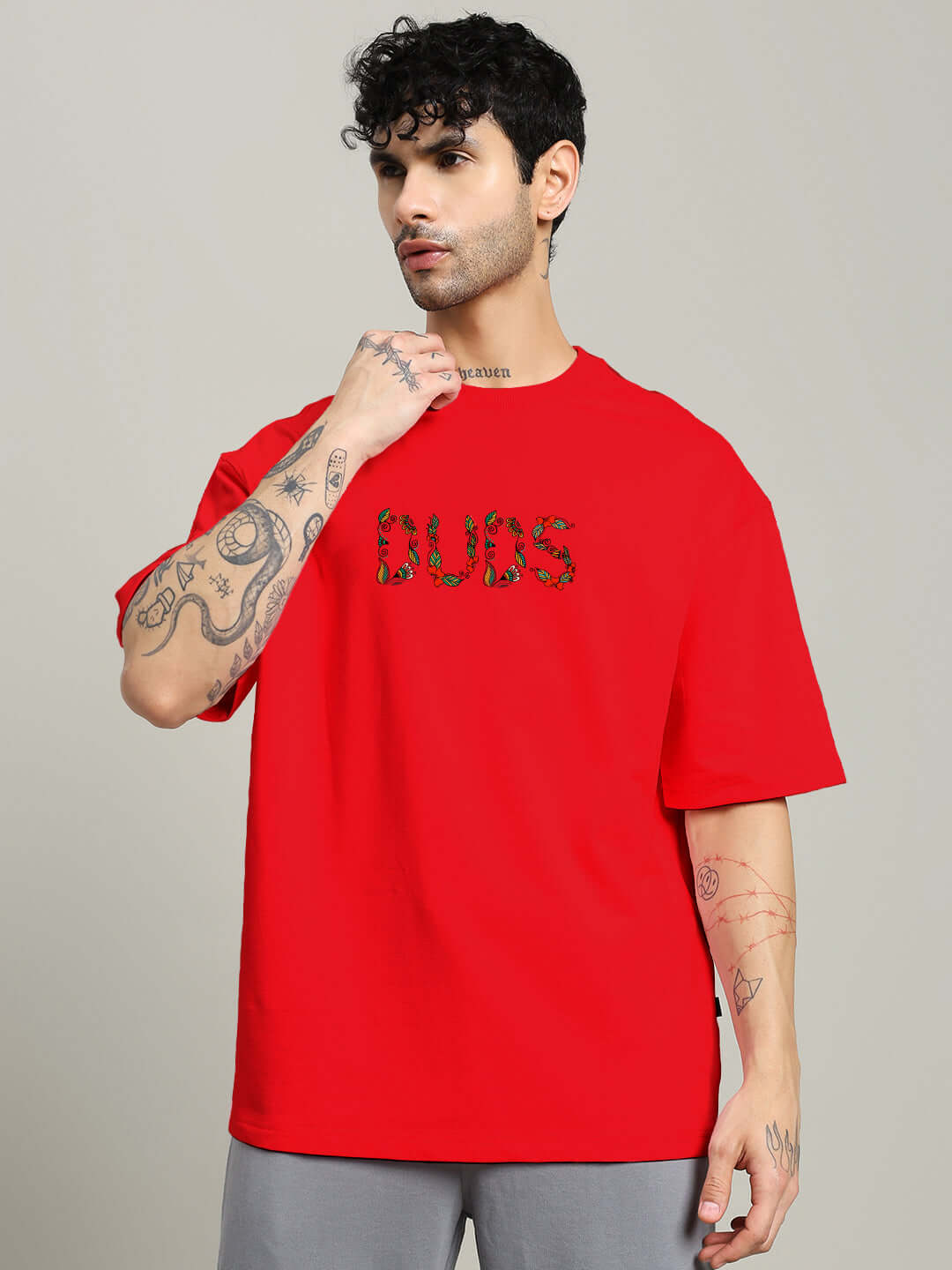 Model wearing red Dragonfly Oversized T-shirt made from premium cotton fabric, styled with visible tattoos, ideal for casual fashion.