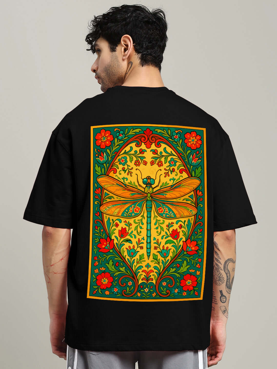 Black oversized t-shirt featuring a vibrant dragonfly and floral design on the back, made from premium cotton blend fabric.