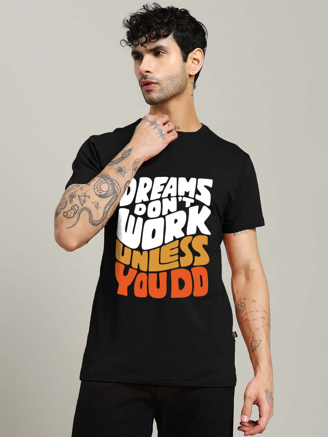 Man wearing a black DREAMS REGULAR FIT T-SHIRT featuring motivational text, made of 100% cotton, by Color By Colours. Casual fashion.