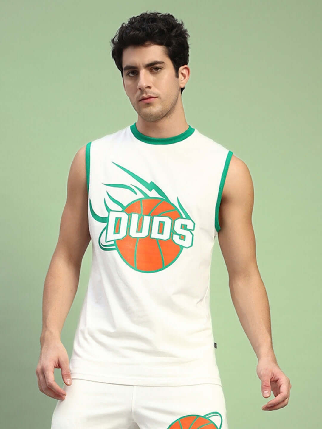 Man wearing a sleeveless white t-shirt with green trim and a DUDS basketball logo, posing against a green background.