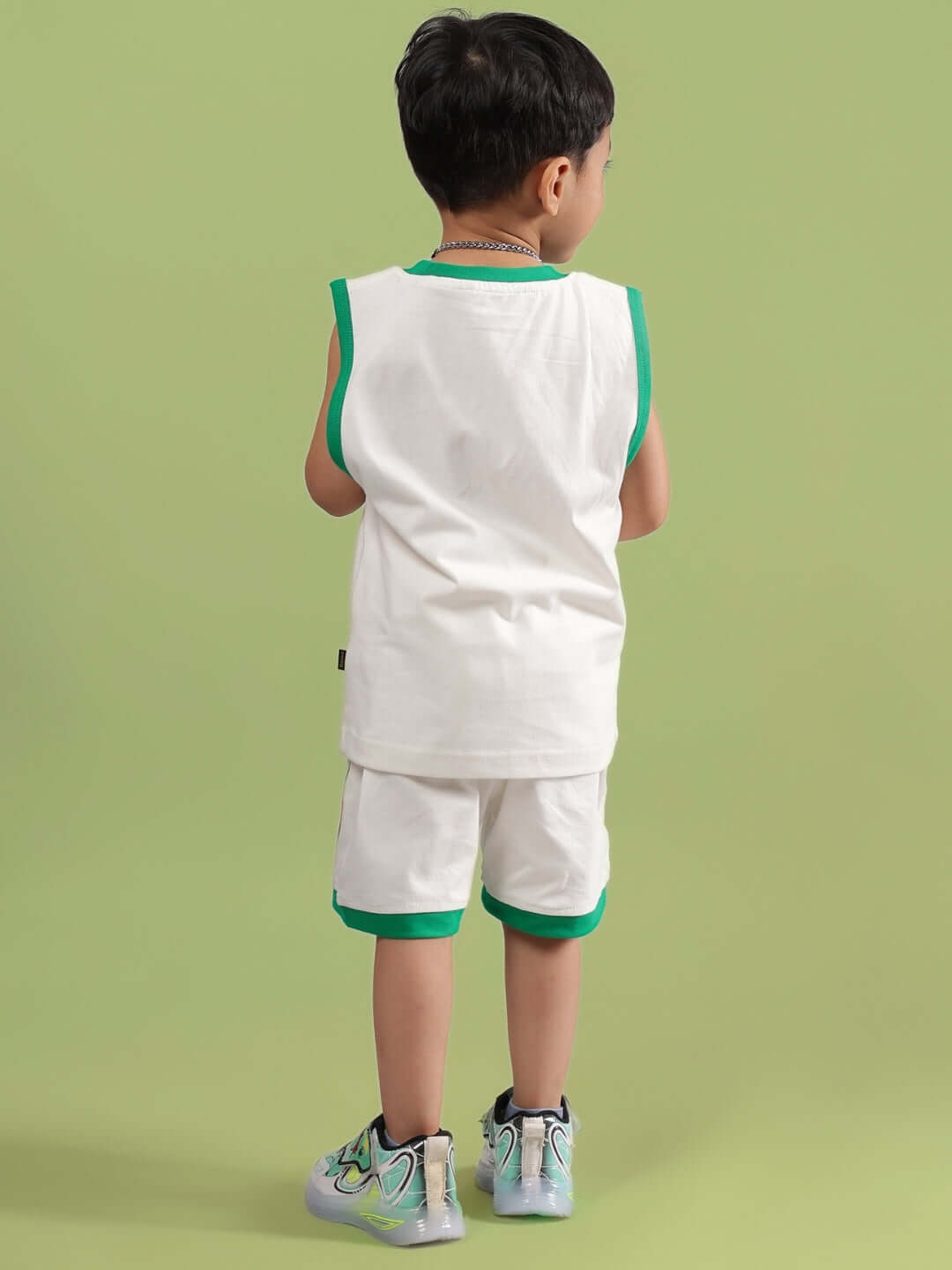 Child wearing off-white DRIBBLE CO-ORD set, suitable for boys and girls, featuring green trim and customizable fit. Made to order.
