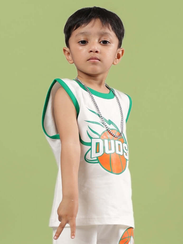 Child wearing DRIBBLE T-SHIRT FOR BOYS & GIRLS OFF WHITE by DUDS with green trim and basketball graphic.