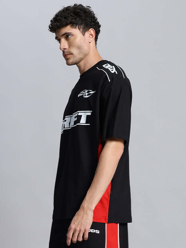 Model wearing black DRIFT oversized t-shirt, showcasing side view and custom fit option availability from DUDS.