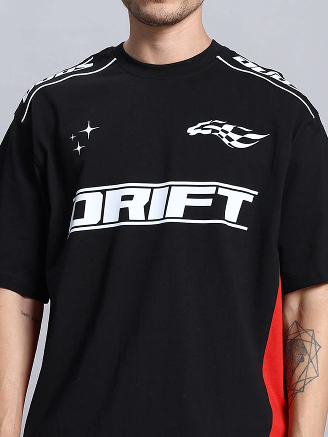 Man wearing DRIFT over-sized black t-shirt with white logo and red detail, customizable with custom fit option for personalized size.