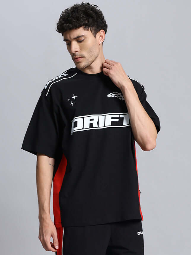 Model wearing black DRIFT oversized t-shirt with red accents, offering custom fit options for personalized style.