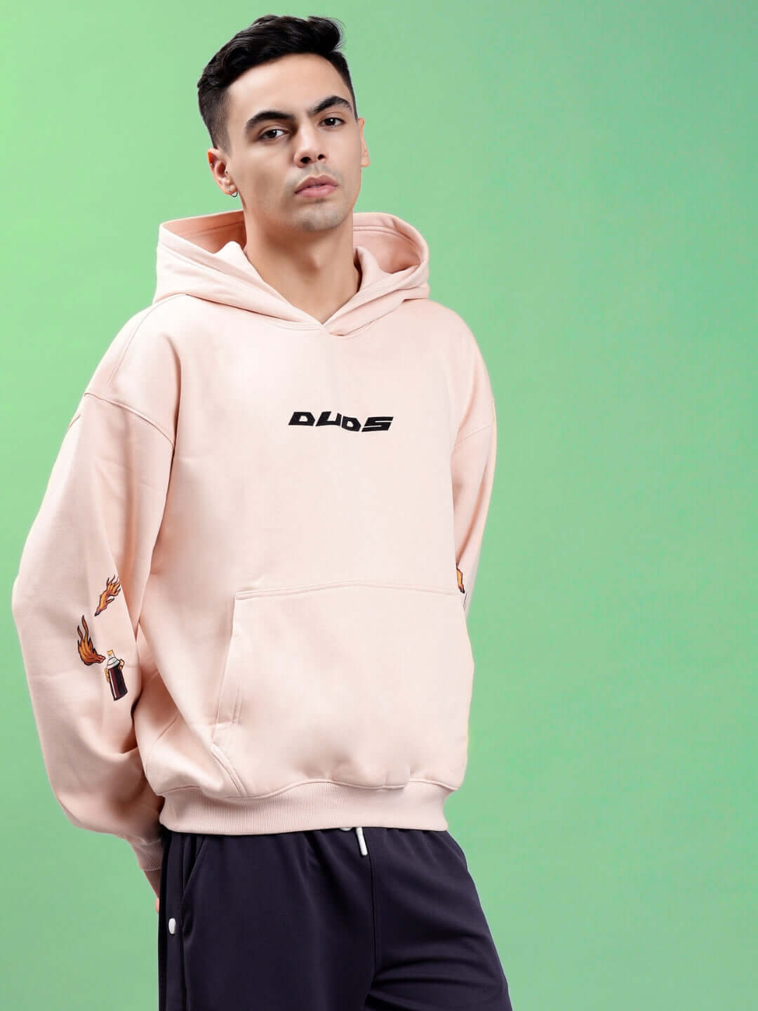 Man wearing DRIP CUPID OVERSIZED HOODIES BEIGE on green background