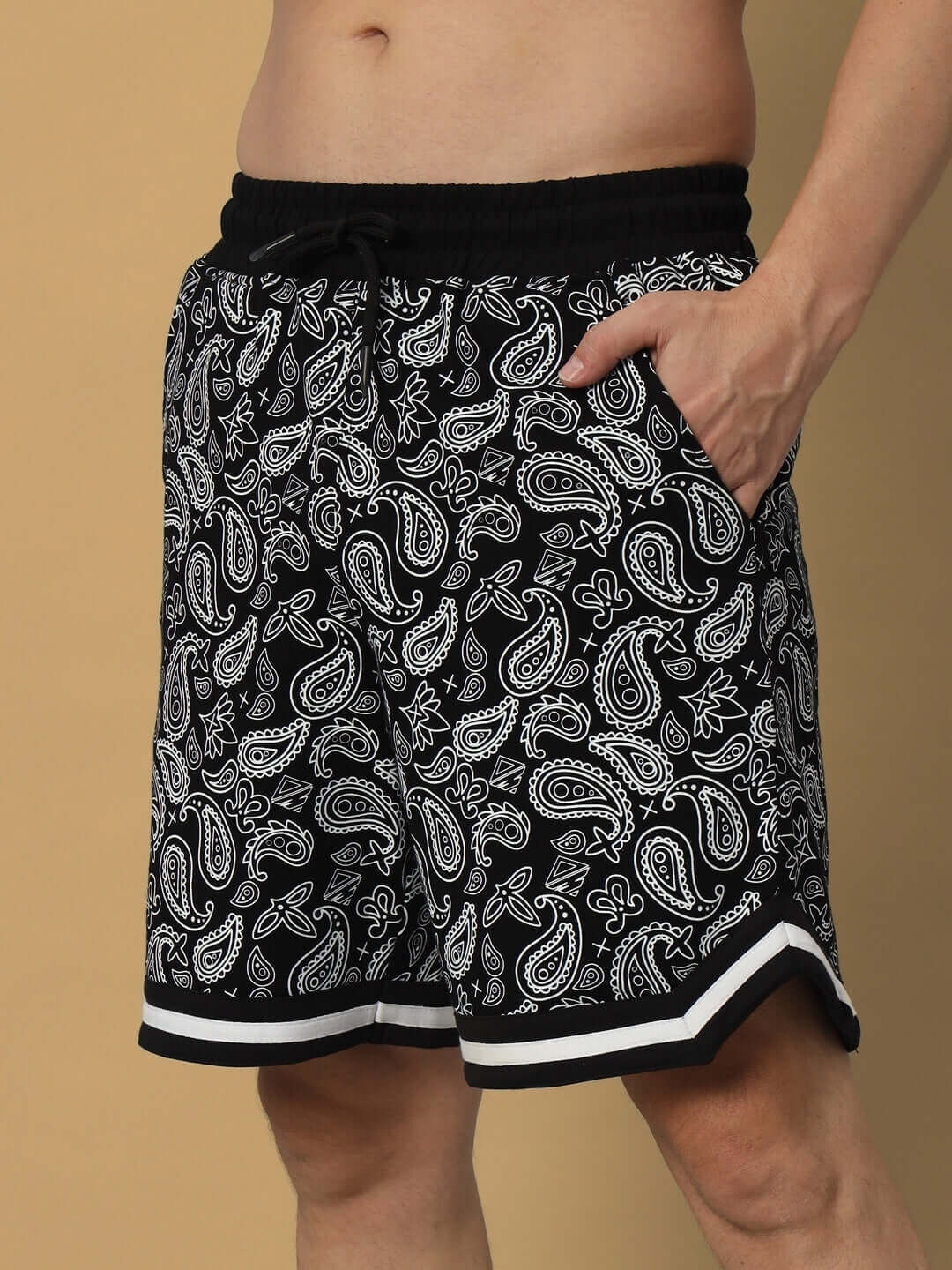 Model wearing Drizzle Regular Fit Black Shorts with paisley pattern and pockets, available in custom fit option.