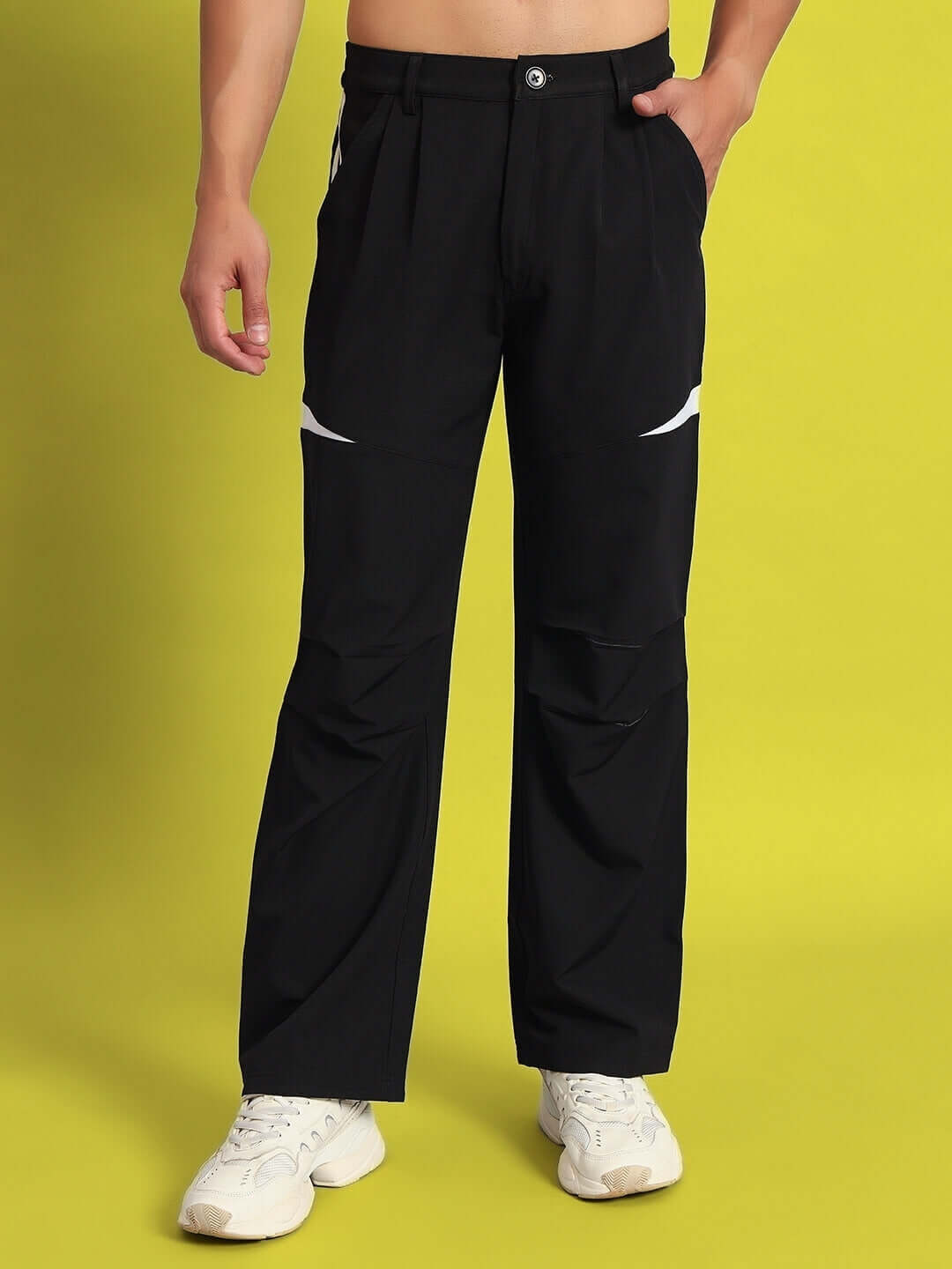 Model wearing DROVE relaxed fit black cargo pants with custom fit option on yellow background