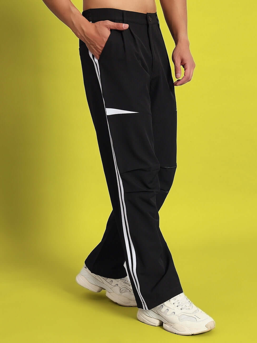 Man wearing DROVE relaxed fit black cargo pants with white side stripes, customizable size option available for personalized fit.