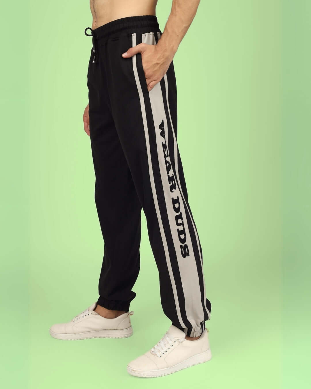 Man wearing DUDS HD Contrast Panel Joggers in black and grey, side view, showcasing stylish design and comfort, perfect for casual wear.