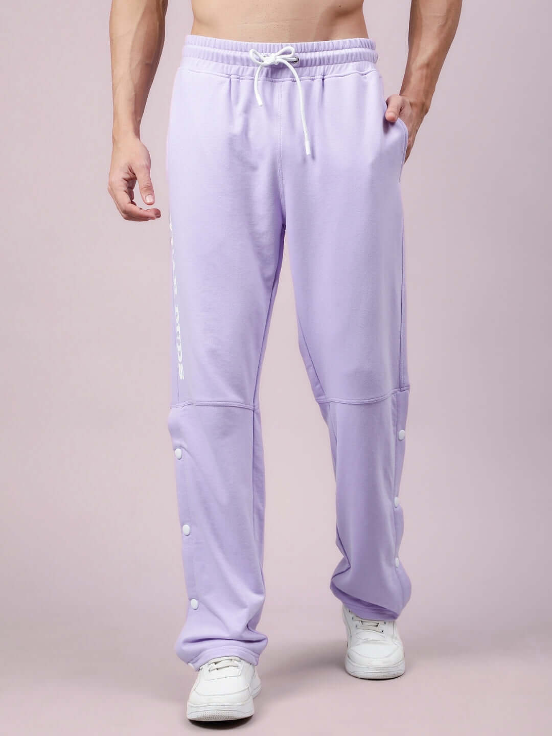 Male model wearing lavender DUDS Racer Joggers, featuring elastic waistband and snap button details, perfect for comfort and style.
