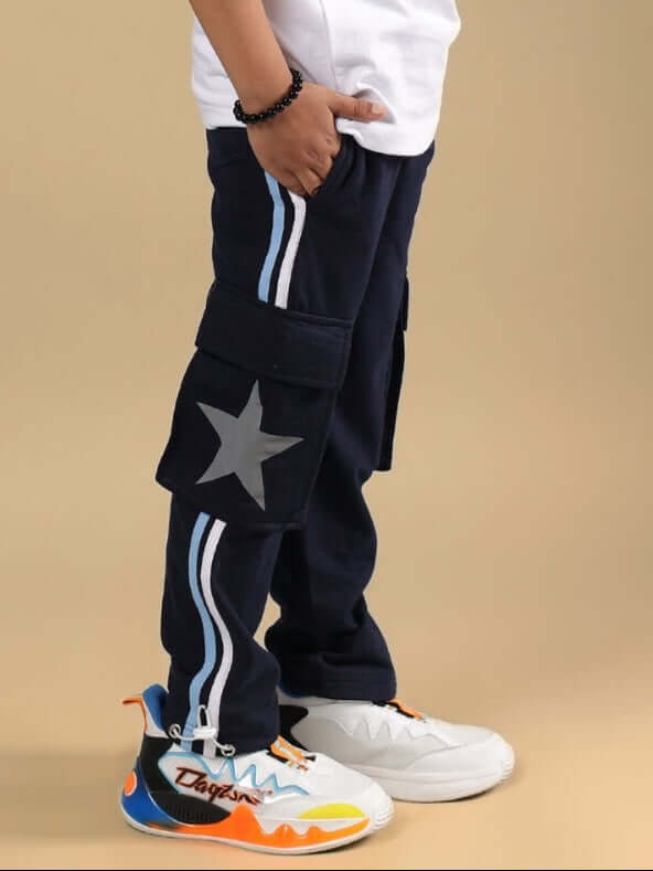 Child wearing DUDS FORCE Navy Blue Jogger with star detail, side pockets, and colorful sneakers.