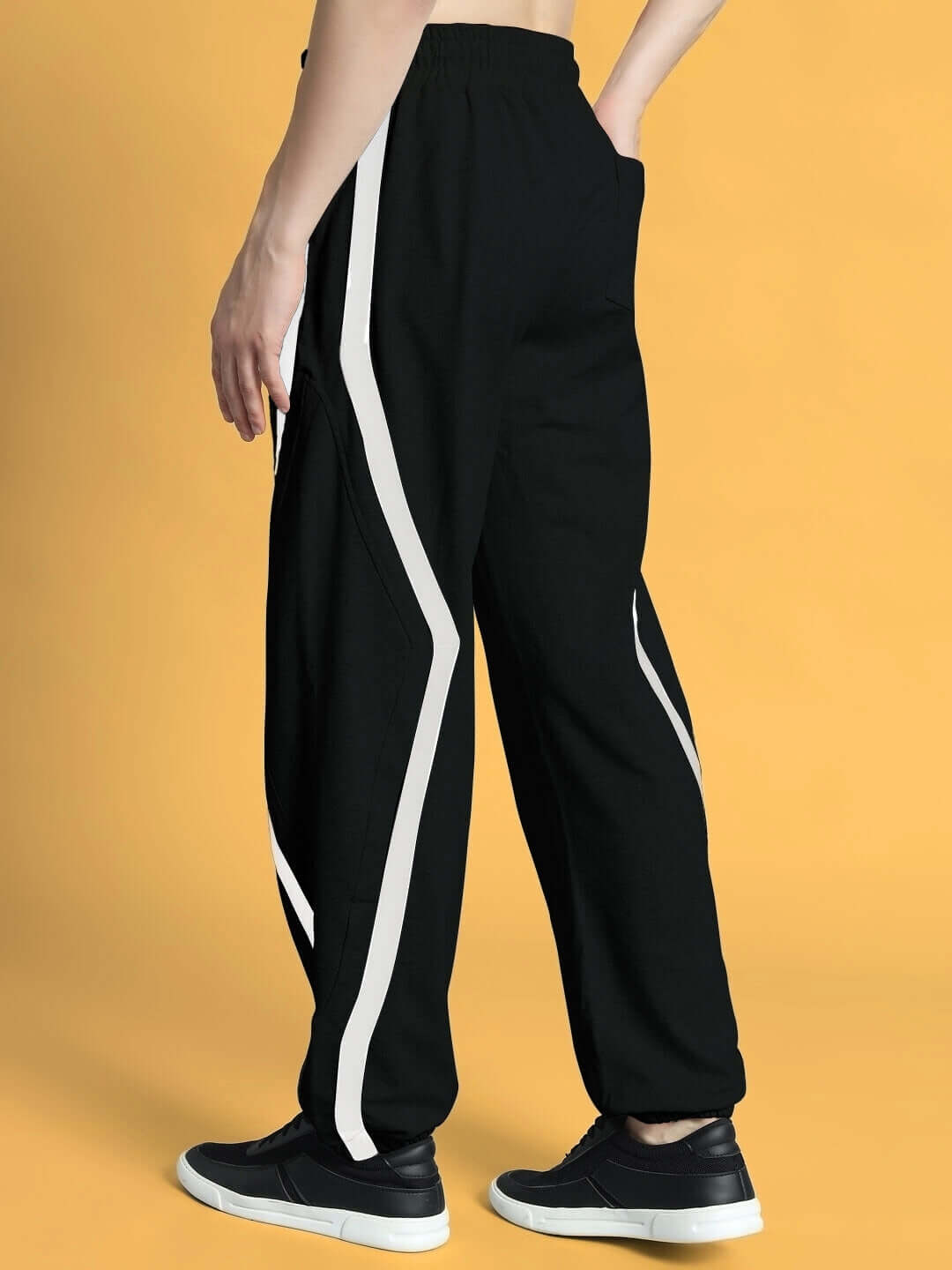 Person wearing DUDS Frame Joggers in black with white stripes, showcasing comfortable and stylish made-to-order design.