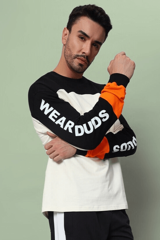 Model wearing DUDS Geometric Oversized Sweatshirt in black and off-white, featuring premium cotton fabric, long sleeves, and bold lettering.