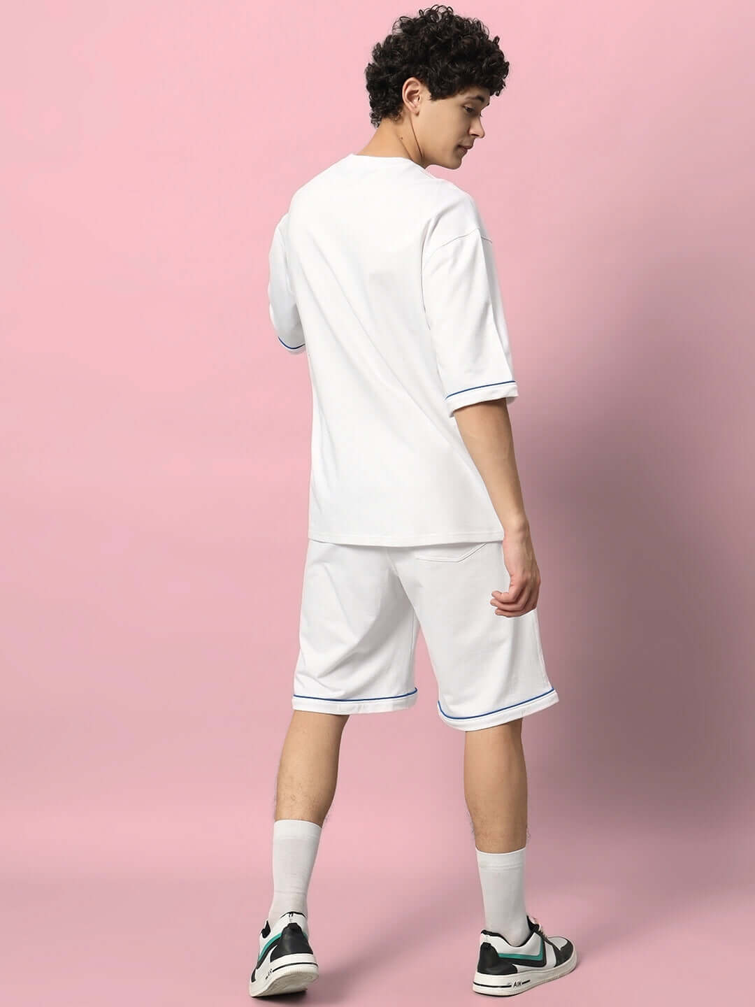 Model wearing DUDS INDA HOUSE white colorblock co-ord set, premium cotton French terry, showcasing style and comfort on pink backdrop.