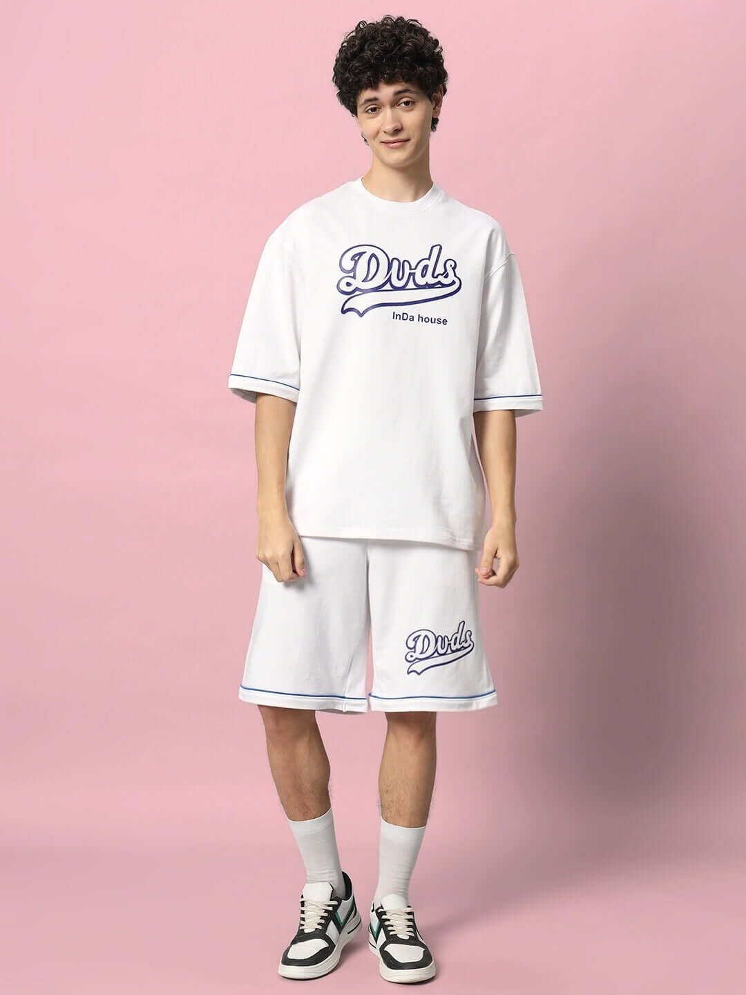 Model wearing DUDS INDA HOUSE white colorblock co-ord set made of premium cotton French terry, standing against a pink background.