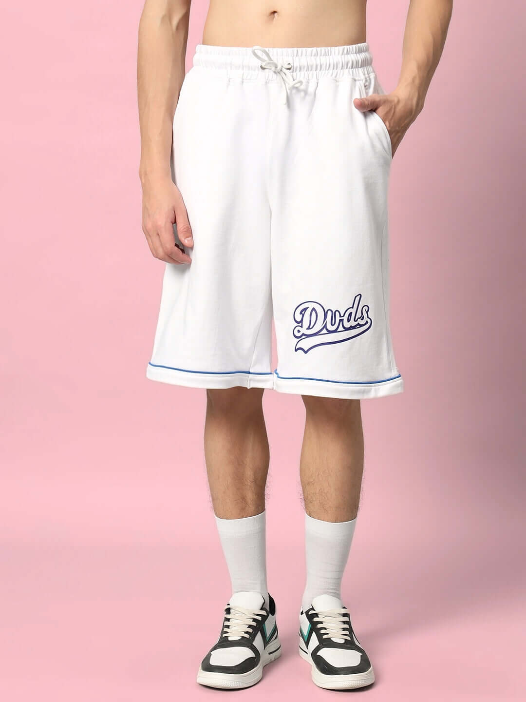 Model wearing DUDS INDA HOUSE white colorblock co-ord shorts, made of premium cotton French terry fabric, showcasing the brand logo.
